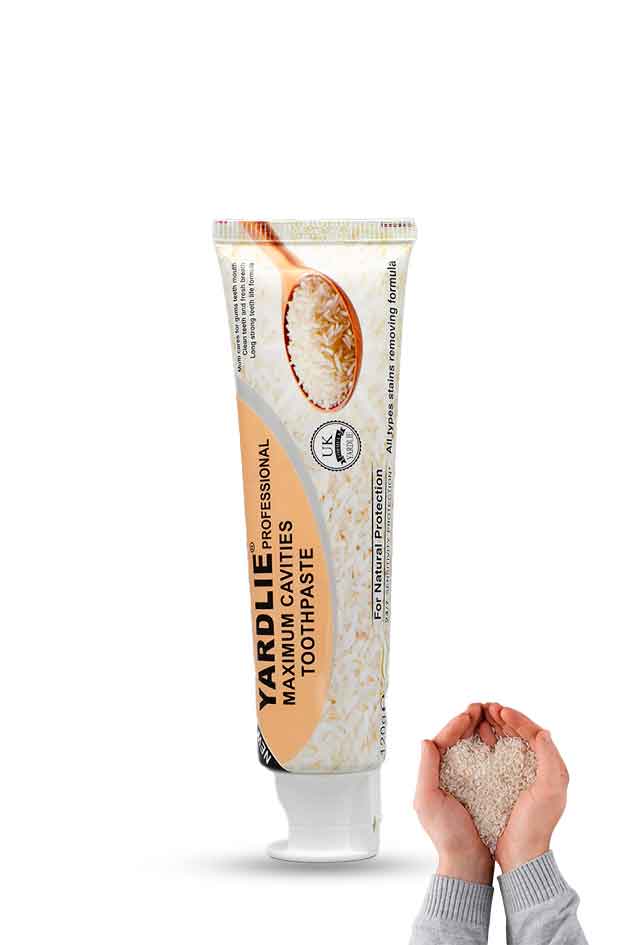 Yardlie Professional Maximum Cavities Toothpaste Tube. Yardley Manuka Honey toothpaste tube with a hand holding a heart-shaped object on a white background