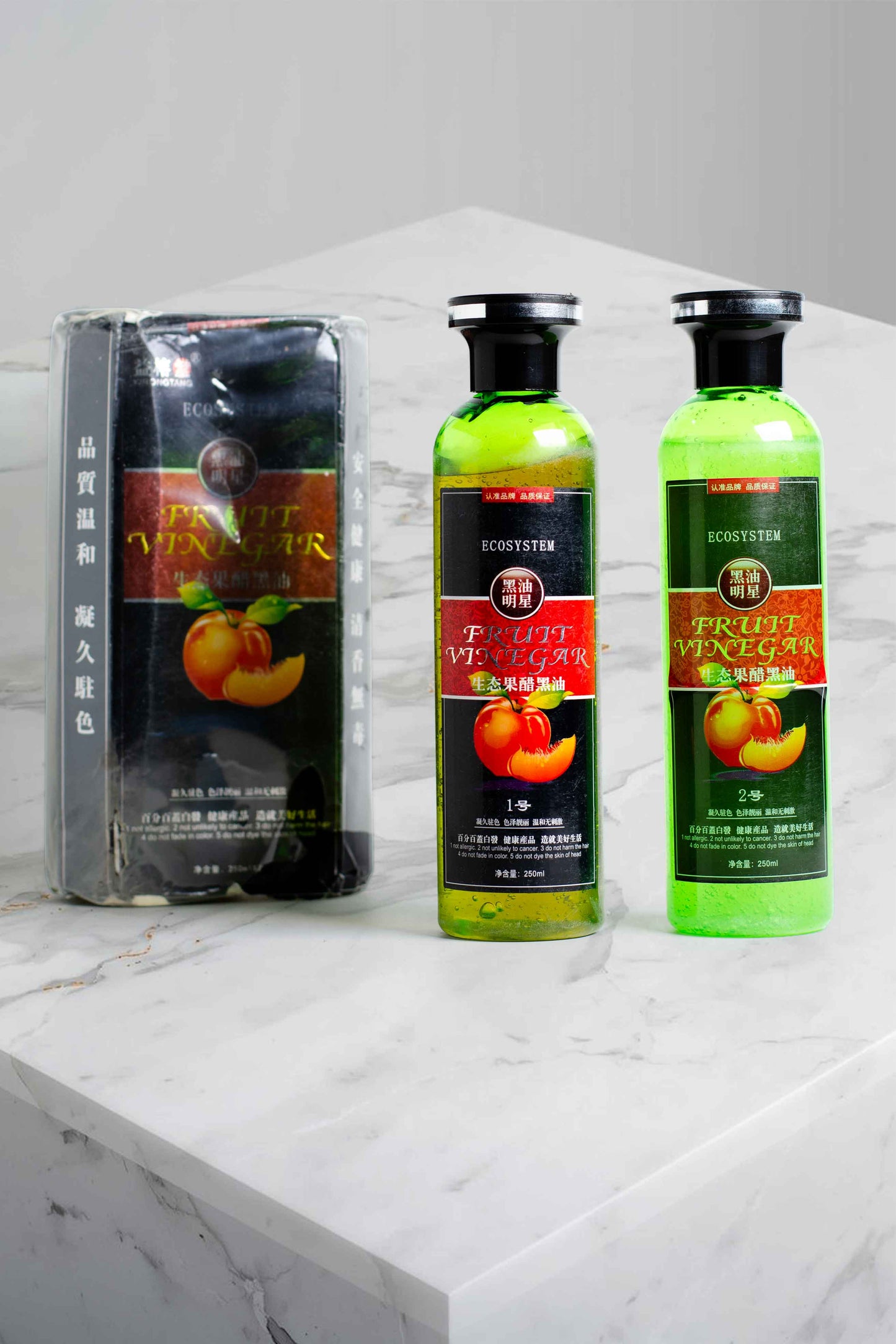 Ecosystem Fruit Vinegar Hair Care Set 250ml bottles with box stock clearance item, Two bottles of fruit vinegar on a marble surface with packaging in the background.