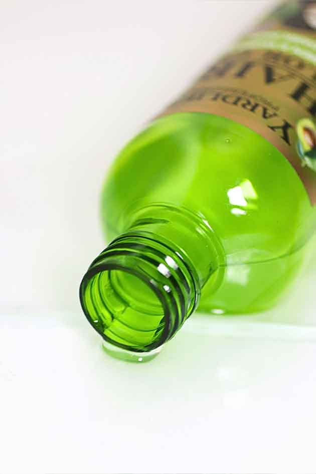 Green bottle with a label on a white background