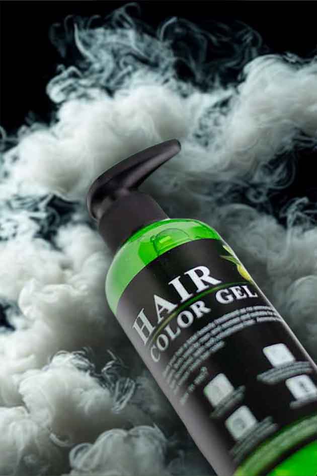 Hair color gel bottle with green label on a white fluffy background