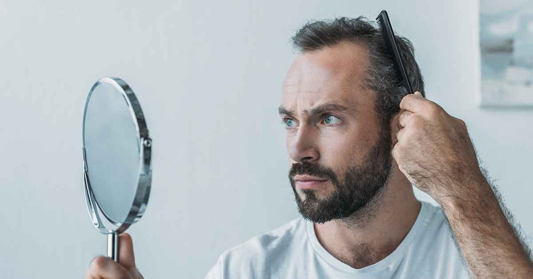 Man noticing gray hair in mirror before using quick hair color shampoo