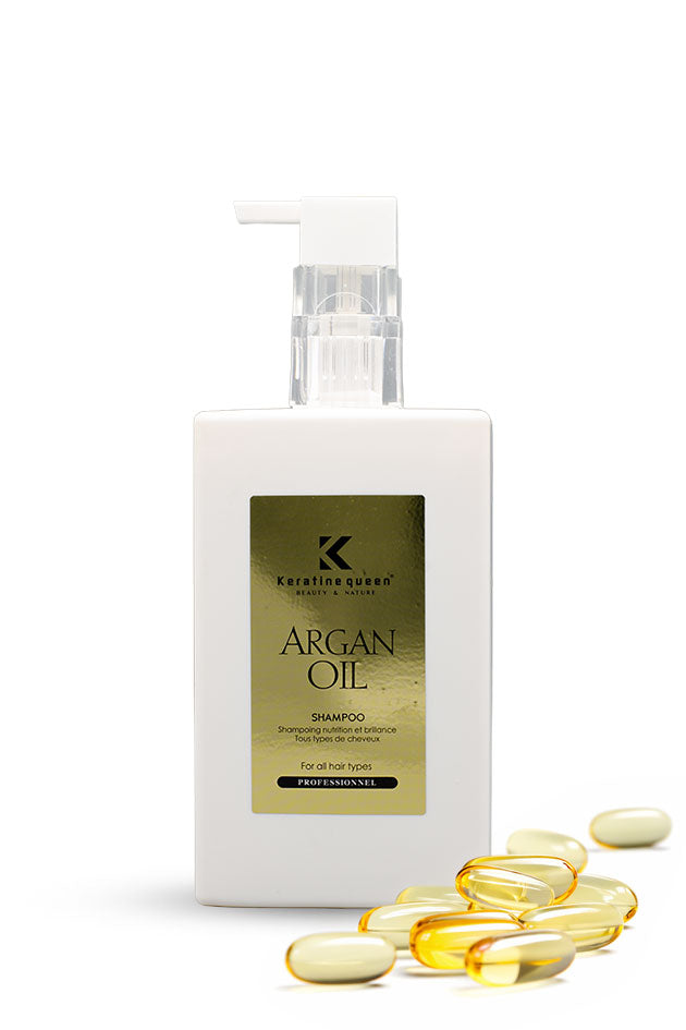 Keratine Queen Argan Oil Anti Dandruff Shampoo 750ml for nourished, smooth, shiny hair,
A white bottle of Karaliyogeo Argan Oil Shampoo with a gold label, shown on a white background with several yellow argan oil capsules in the foreground.