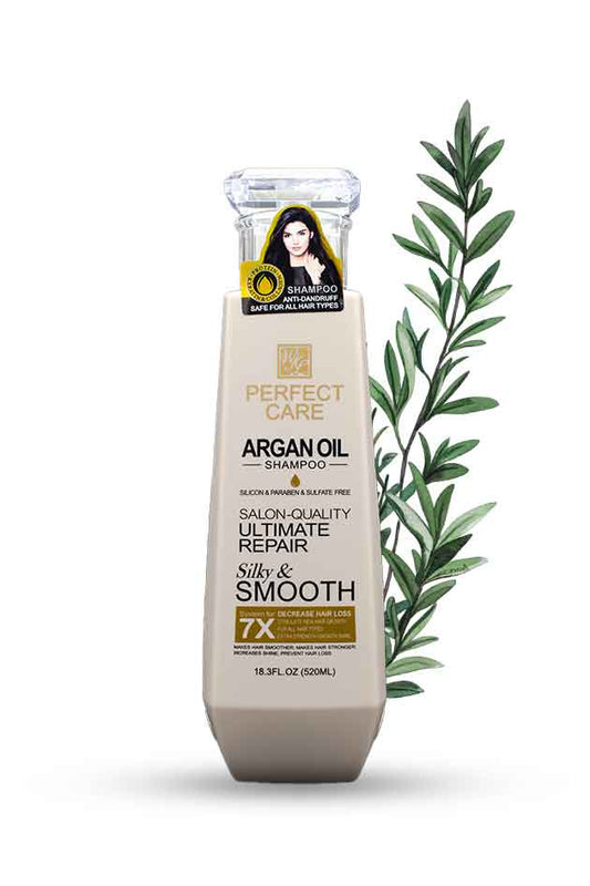 Shampoo bottle with argan oil label and green leaves on a white background