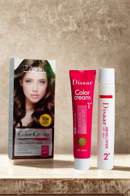 Applying Disaar Dark Brown hair dye cream for soft, shiny, and youthful hair results. Disaar hair color cream and developer with packaging on a wooden surface.