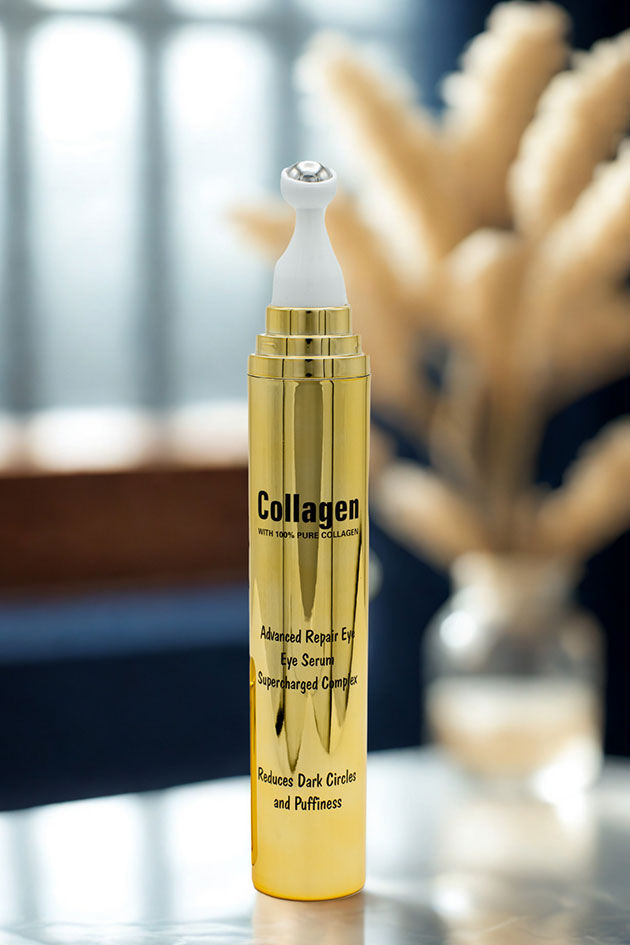 Wokali collagen eye serum on marble surface with window light Gold collagen eye serum bottle on a reflective surface with blurred background