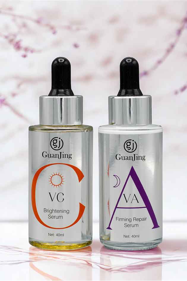 Two skincare serum bottles with droppers on a marble surface.