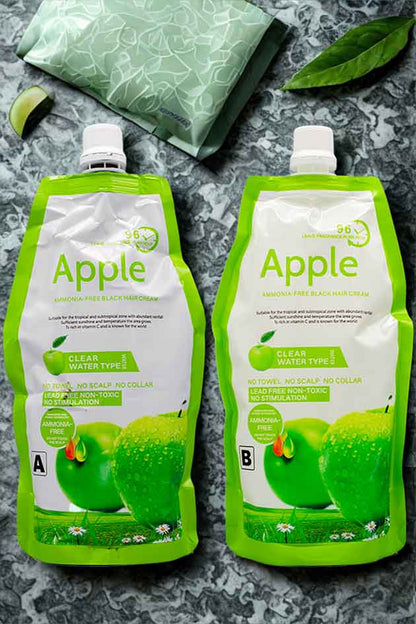 Two green Apple juice pouches on a gray surface with a green bag and leaves in the background.