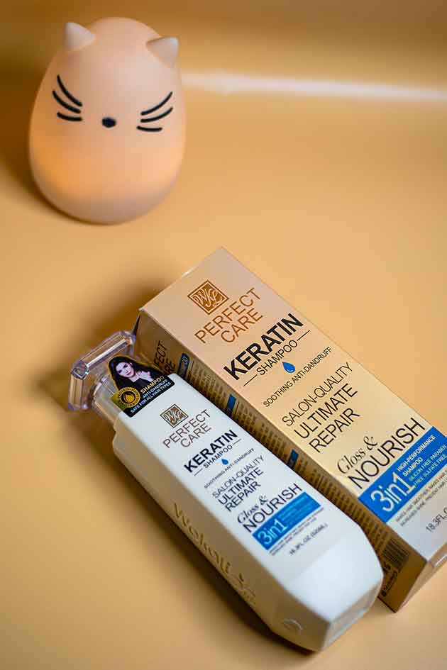 Yardlie Keratin Shampoo with keratin essence and natural ingredients flat lay. Perfect Care Keratin hair care product packaging on a beige background with a small cat-shaped night light.