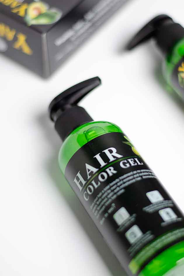 Hair color gel bottle with green label and black pump on a white background