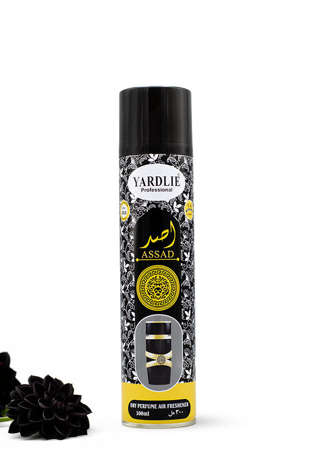 Yardlie Professional Assad Dry Perfume Air Freshener 300ml black and gold can,
A 300ml aerosol can of Yardlie Professional Assal No Perfume Air Freshener, featuring a black cap and a black-and-white patterned label with gold accents, set against a plain white background with a black flower prop at the bottom left.