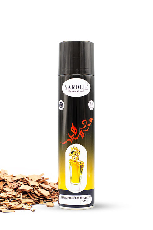 Yardlie Professional Oud Mahir Dry Perfume Air Freshener 300ml black and gold can,
A can of Yardlie Pharmaceutical fragrance oil spray with a black cap and a black-to-yellow gradient label, shown on a white background with wood shavings on the left.