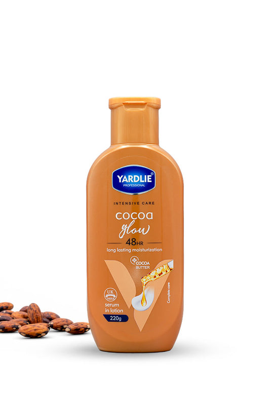 Yardlie Professional Cocoa Glow cocoa butter serum in lotion body lotion 220g bottle for dry skin,
A bottle of Yardlie Cocoa Glow 45min long lasting moisturizer in a warm brown shade, shown on a white background with cocoa beans on the left.